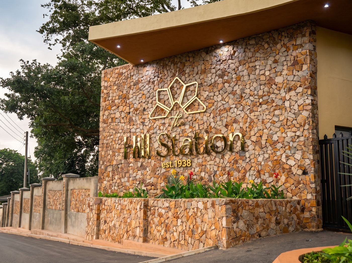 The Hill Station entrance sign, established 1938, set into a stone wall